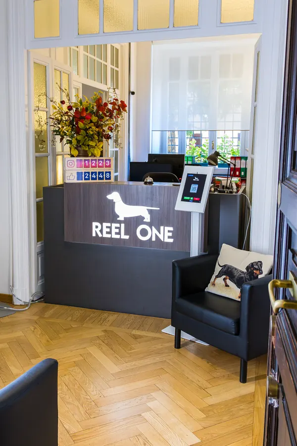 Il bancone della reception con il logo Reel One e la poltrona