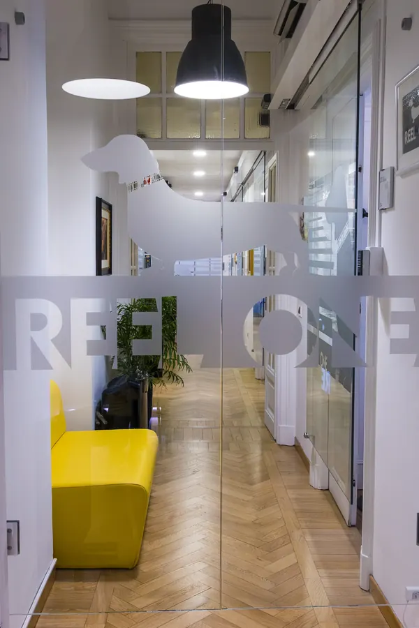 La porta a vetri con il logo Reel One, vista dal corridoio