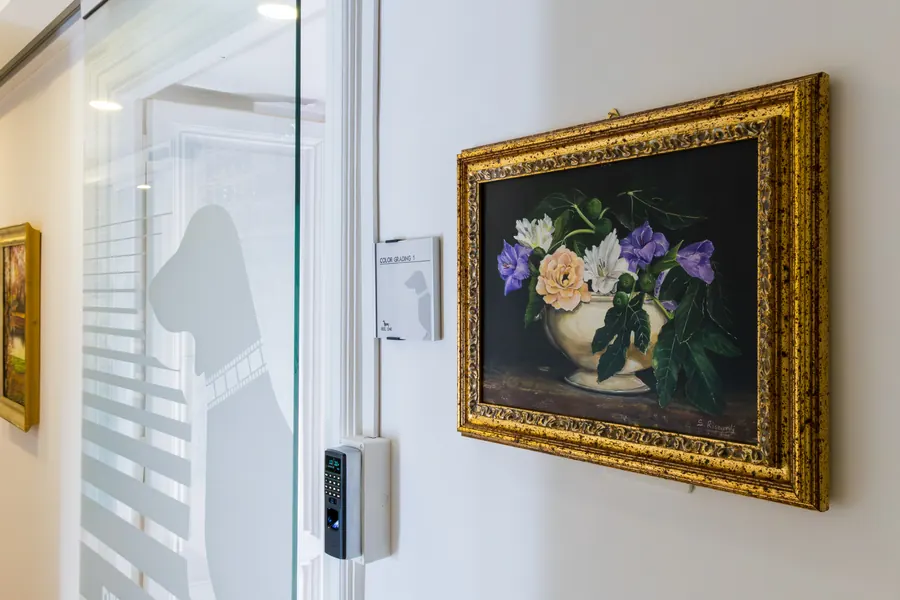 Un quadro con cornice dorata accanto alla porta a vetri