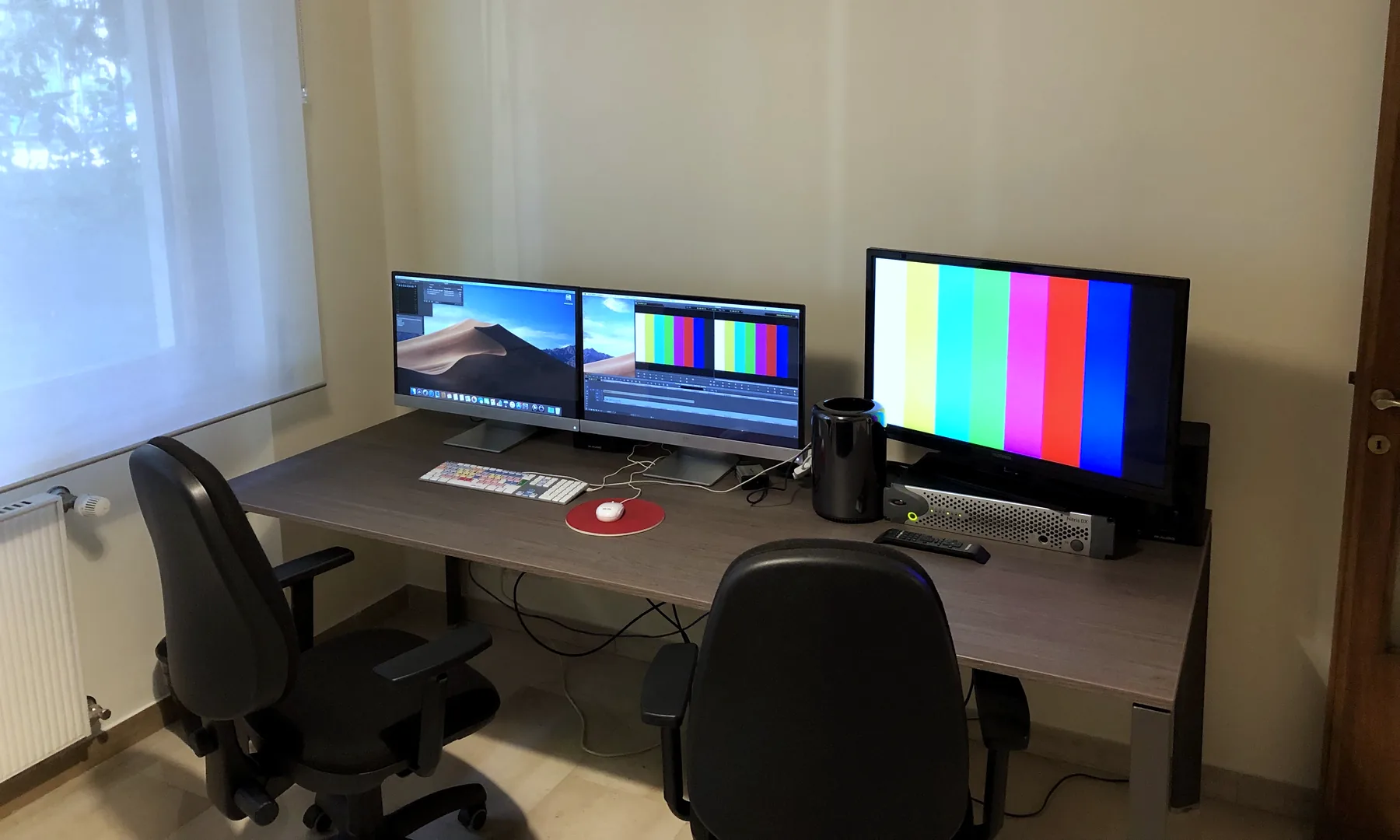 Una sala montaggio a noleggio: scrivania con due monitor e monitor di riferimento
